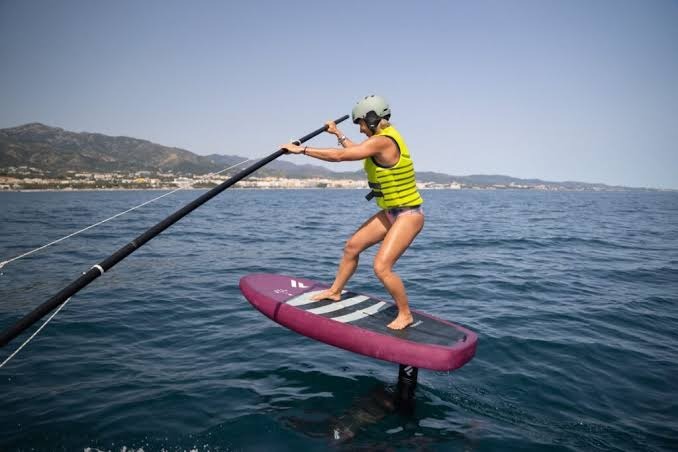 Practicante de wing foil navegando cerca de la costa de Puerto Velero